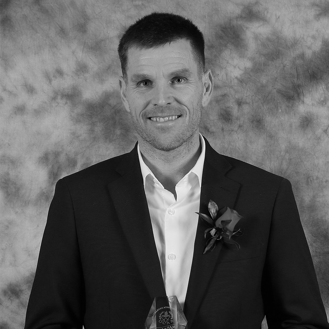 David Sharratt black and white photo in from of a ocaa background.